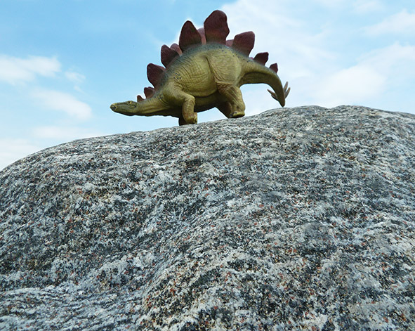 dinosaur standing on big cliff